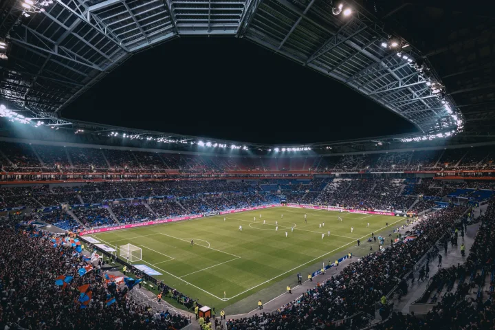 A football match seen from the stands of a packed stadium